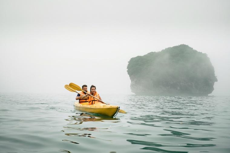couple-paddling-the-kayak-in-misty-weather.jpg